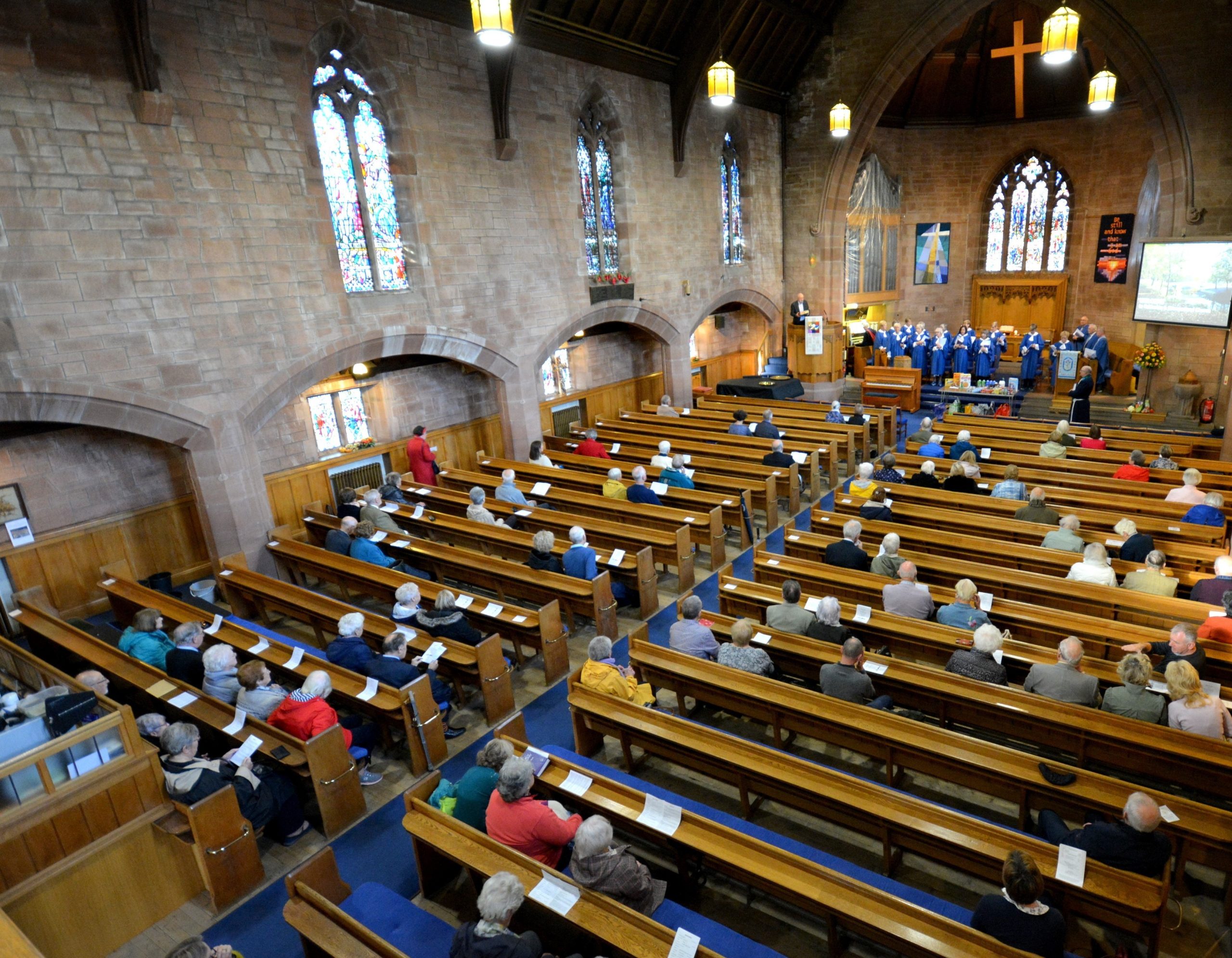 Church sanctuary with people sitting in pews